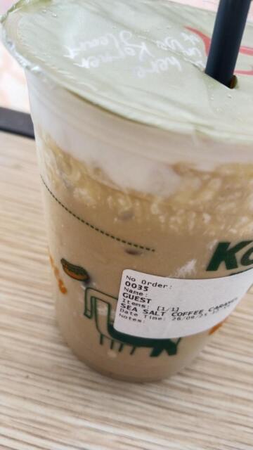 Potret kopi dari jarak dekat dengan tempelan kertas bertulis sea salt caramel